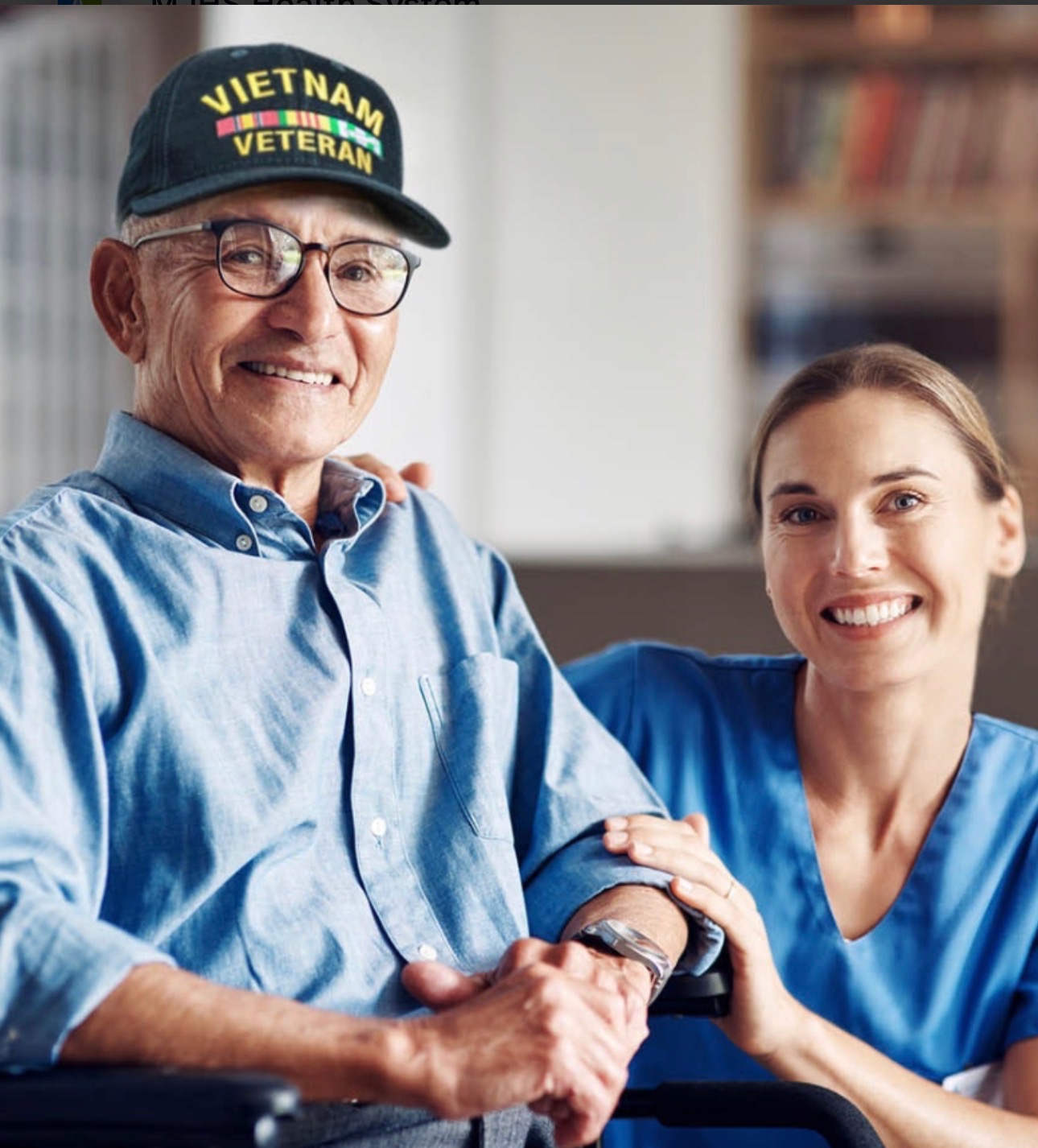 A smiling Vietnam veteran with his caregiver at home